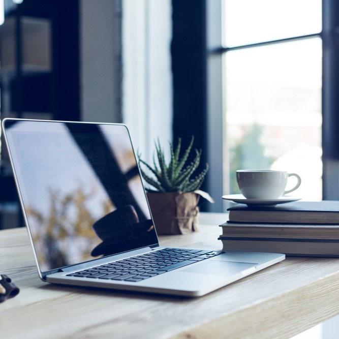 Coffee cup and laptop on a desk